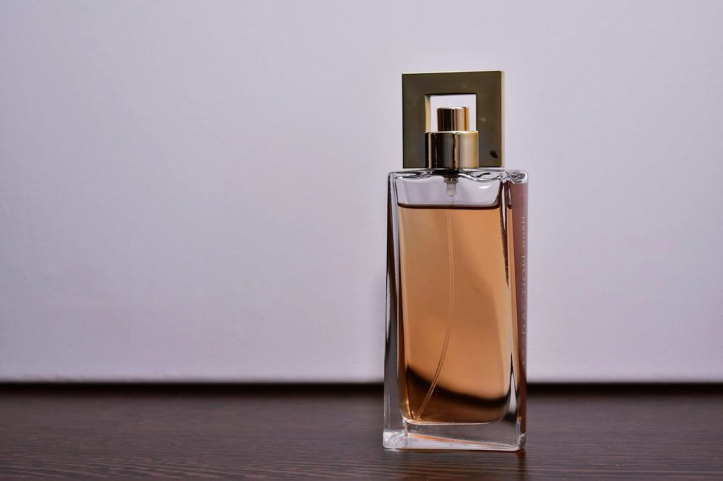 Stylish close-up of a transparent glass perfume bottle on a wooden surface.